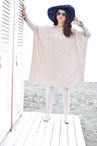 Oversized beige linen dress with a loose, flowy silhouette and wide sleeves. Designed for comfort and effortless style, featuring soft, breathable fabric. The sleeves have delicate tie details at the wrists, adding a subtle touch of charm