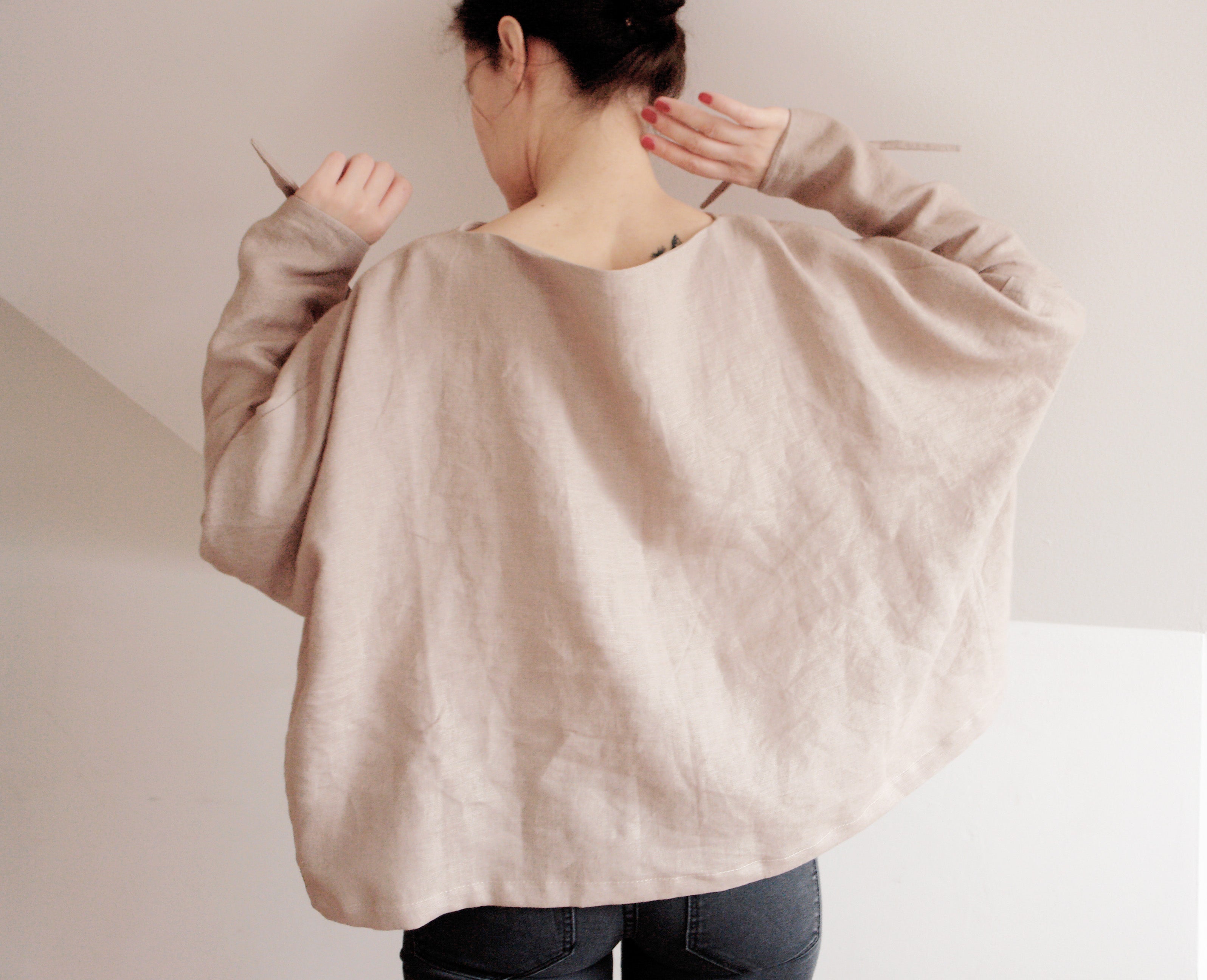 Elegant oversized linen kimono top in a soft beige color. Designed with wide, draped sleeves for a relaxed fit and stylish tie details at the wrists. Crafted from breathable, natural linen for a lightweight and comfortable feel. A perfect blend of minimalism and effortless sophistication