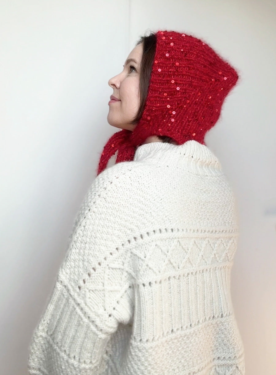 Winter fashion accessory: red bonnet with sequins, handmade and modeled for a cozy seasonal look. Perfect for photoshoots, gifting, or daily wear.