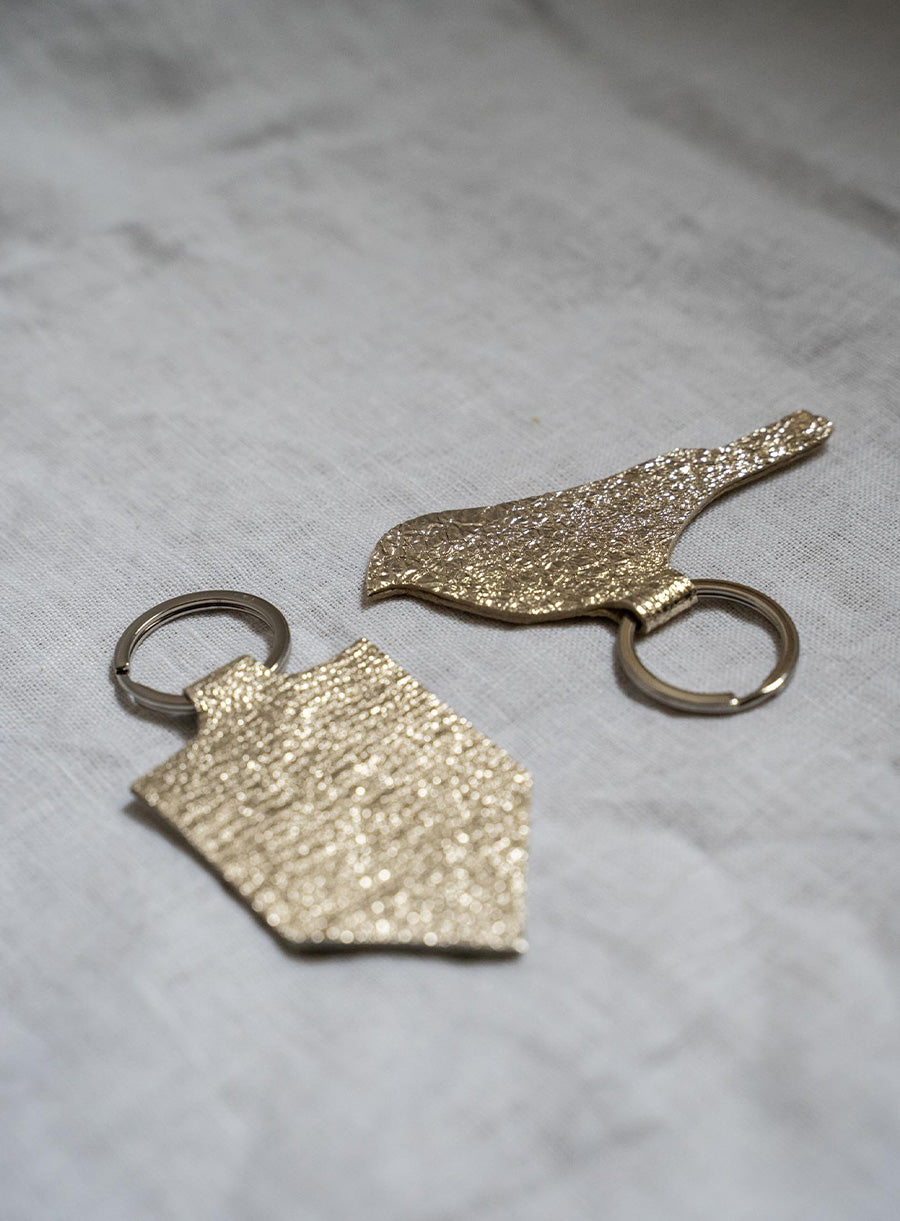 Handmade gold bird keychain with textured leather design, minimalist key ring for bird lovers and unique gifts.