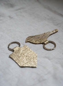 Handmade gold bird keychain with textured leather design, minimalist key ring for bird lovers and unique gifts.