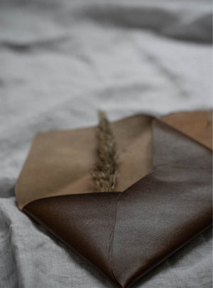 Rustic wedding invitation suite with leather-bound details, wax-sealed envelopes, and vintage-inspired typography. Unique, handcrafted design for an unforgettable wedding announcement.