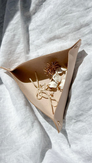 Elegant leather storage tray for knitting and crochet accessories, featuring delicate stitch markers inside