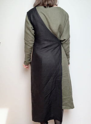 Back view of the Linen Apron Dress in black, highlighting the cross-back strap design and knee-length cut.
