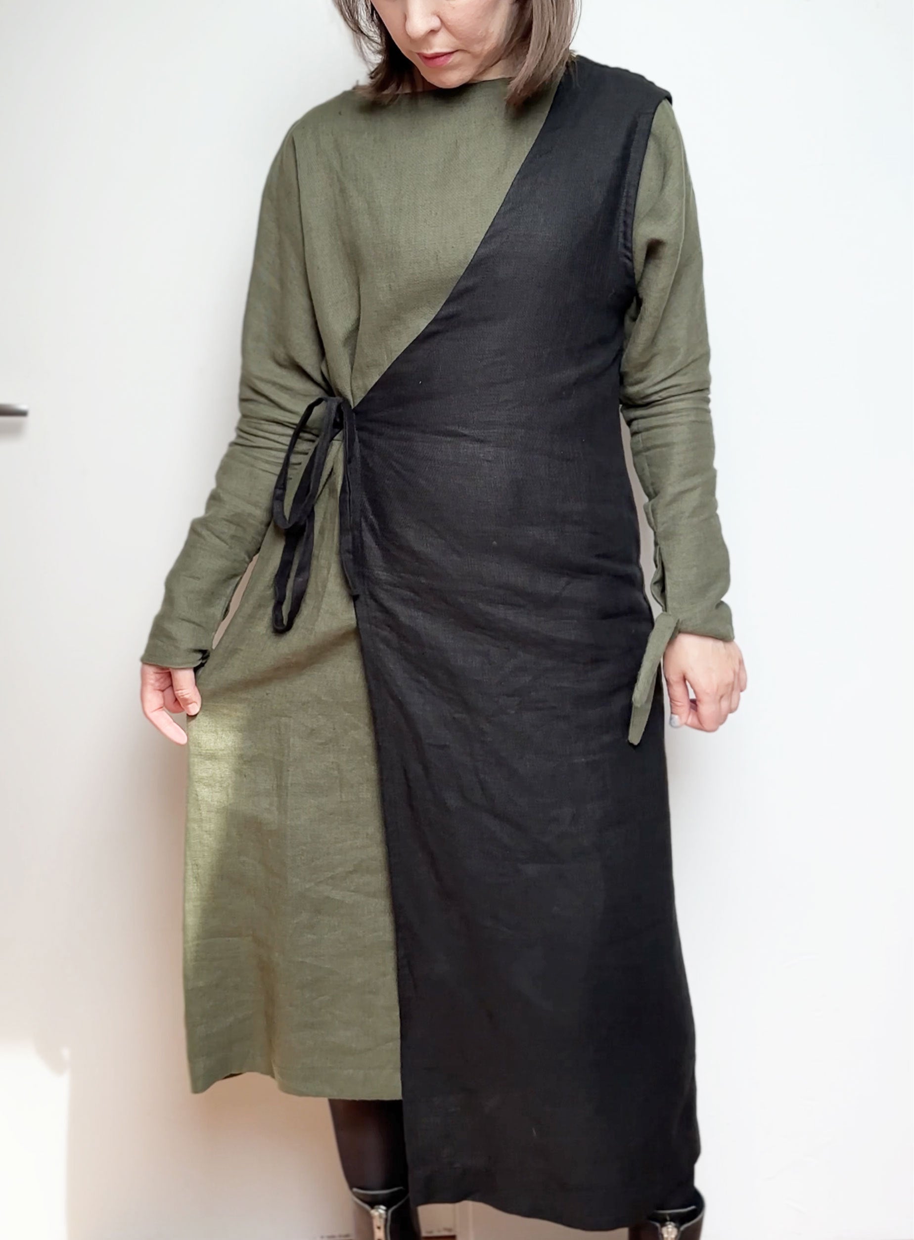 black asimetric vest in wabi sabi style wearing over the linen dress