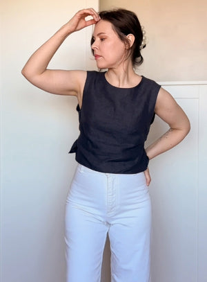 Simple and breathable black linen top with side ties, styled in a modern neutral outfit for summer or spring.
