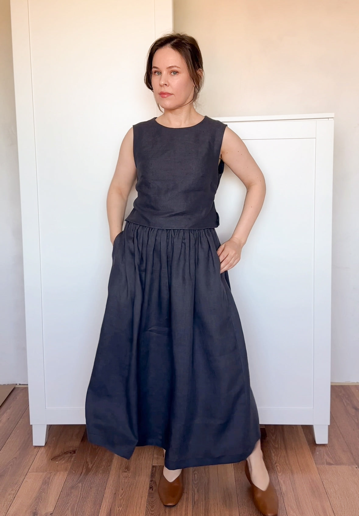 Classic and timeless black linen skirt with a natural drape, styled in a monochromatic summer look.