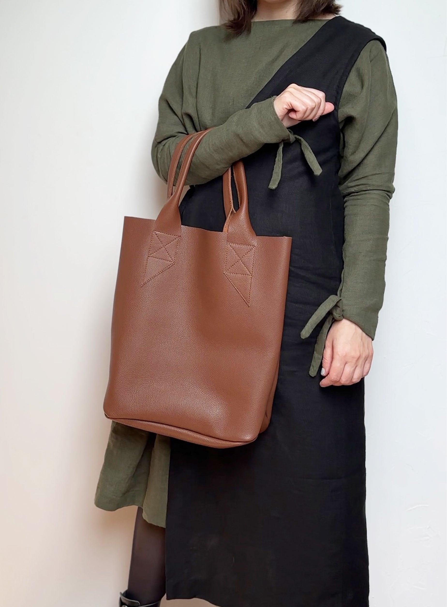 Interior of the leather tote bag in brown,  displaying the unlined suede finish and key hook detail.