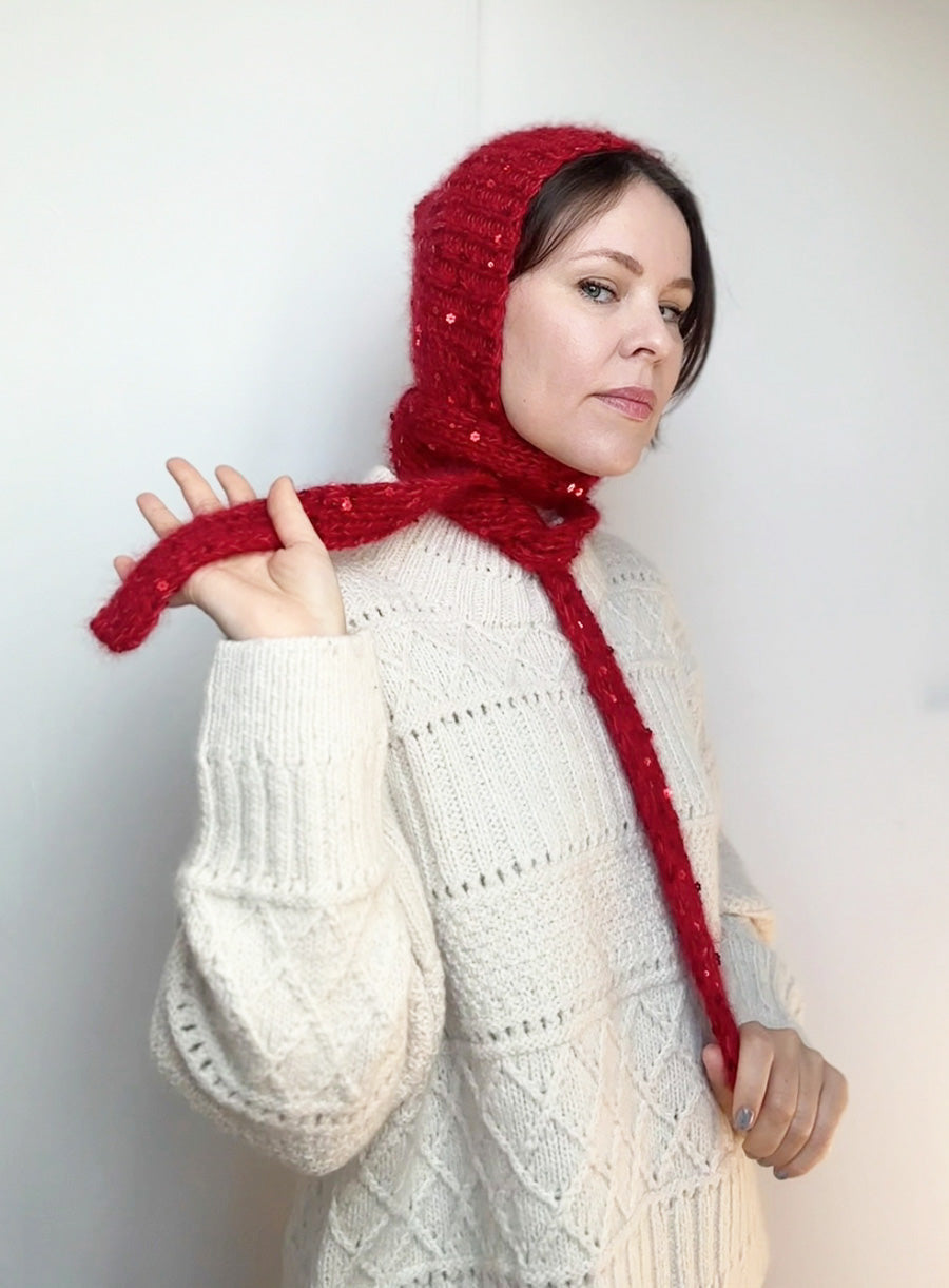 Handmade red sequin bonnet on a woman, styled like a fairy tale character. A magical accessory for cold weather and whimsical fall fashion.