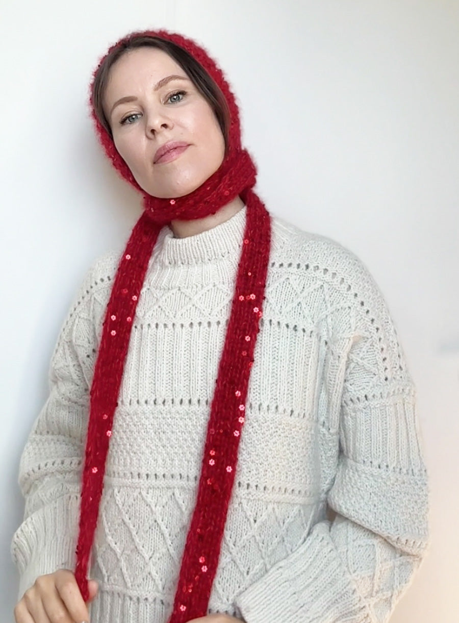 Side view of a woman modeling a red sequin bonnet tied under the chin, styled for fairy tale-inspired outfits, ideal for fall and winter fashion lovers.