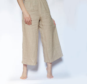 Casual, flowy beige pants with a soft drape and minimalistic style.