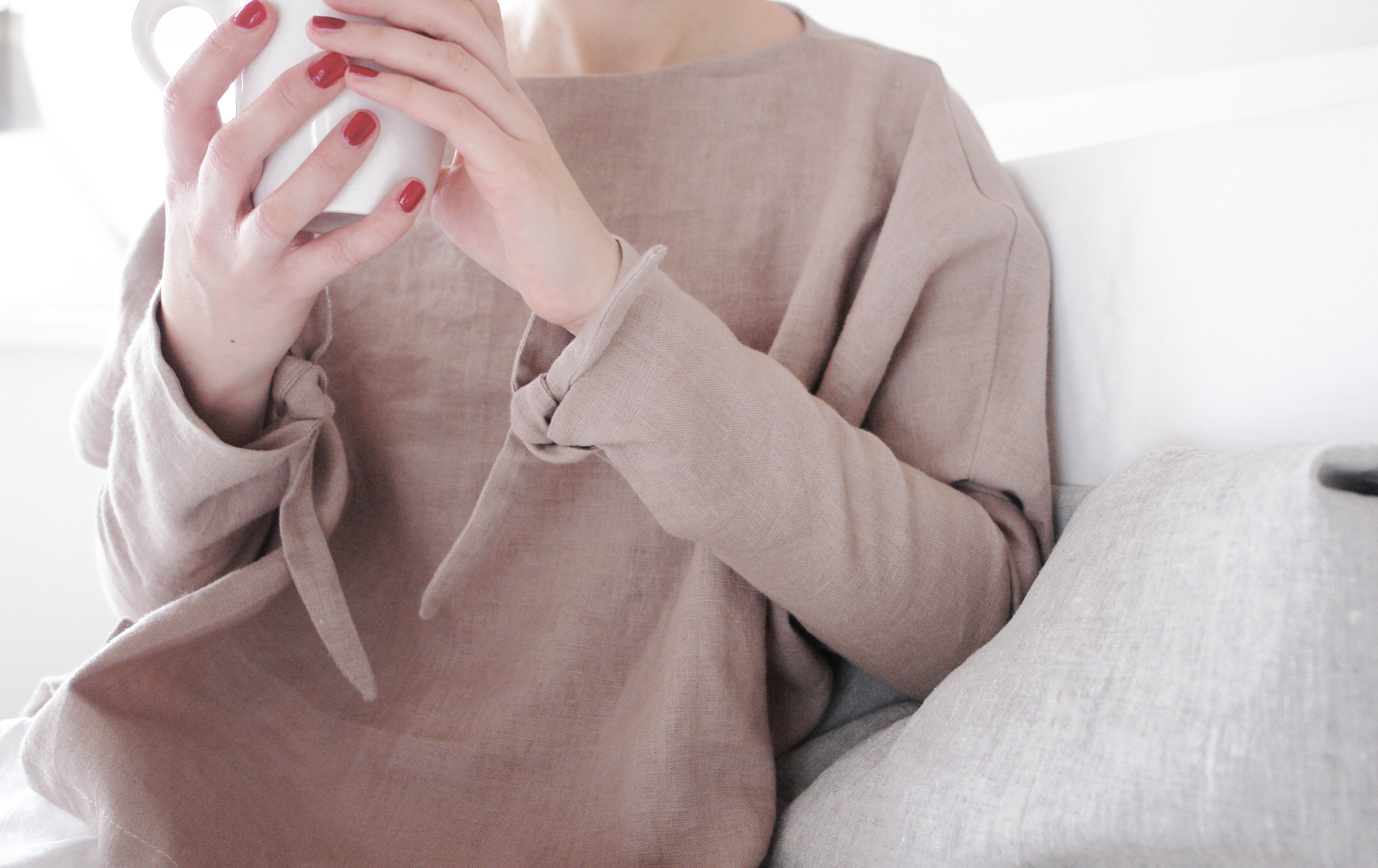 Cozy yet stylish linen kimono top in a warm beige hue. Featuring flowy batwing sleeves and delicate wrist ties, this relaxed-fit blouse is perfect for layering or wearing on its own